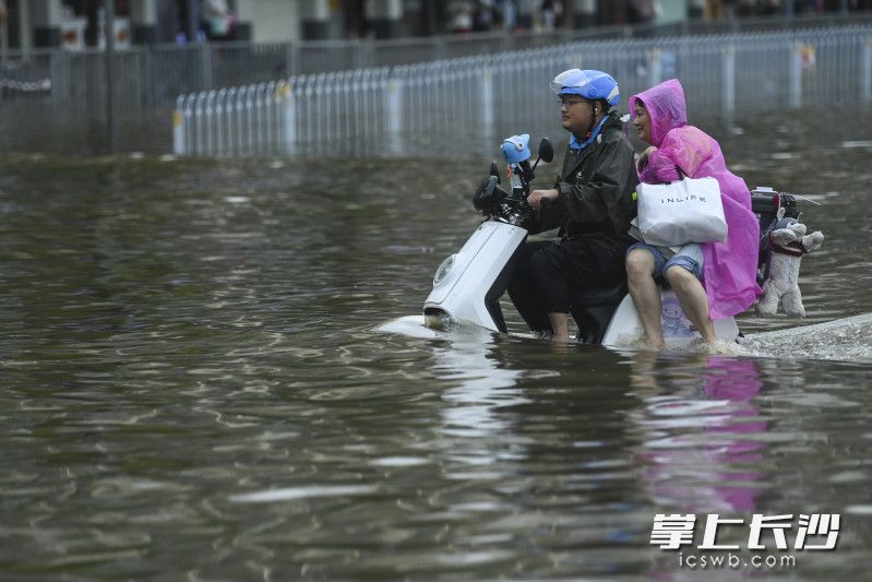 6月24日14時35分,，芙蓉區(qū)車站中路長沙火車站錢，同一位外賣小哥載著另外一位旅客再次通過積水路面,。