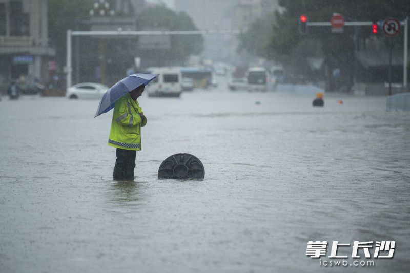 6月24日14時59分，芙蓉區(qū)車站中路,，市政工作人員守著一處排水井,，提醒著冒險涉水通行的車輛和行人,。