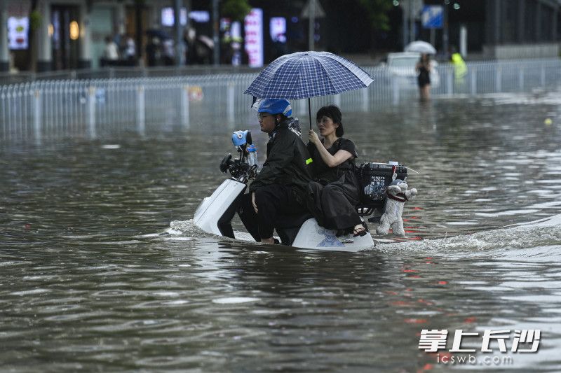 6月24日14時33分,，芙蓉區(qū)車站中路長沙火車站錢，一位外賣小哥載著一位旅客通過積水路面,。