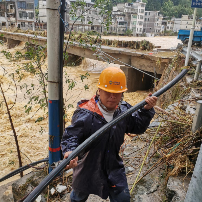 圖為湖南移動網(wǎng)絡(luò)搶修突擊隊(duì)員在郴州汝城南洞鄉(xiāng)跨河布放光纜。