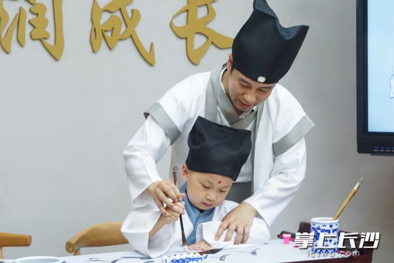 書院小學(xué)校長胡云華化身古代教書先生,，帶領(lǐng)一年級新生開筆寫字,，傳承中華傳統(tǒng)文化。學(xué)校供圖