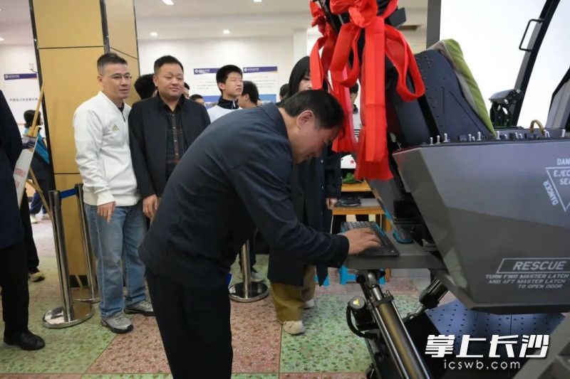 長郡中學校長鄧智剛接過操作手冊并輸入密碼,，開啟飛行設(shè)備。