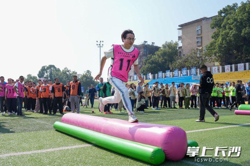 在比賽項(xiàng)目“披荊斬棘”中,，選手躍過“獨(dú)木橋”。