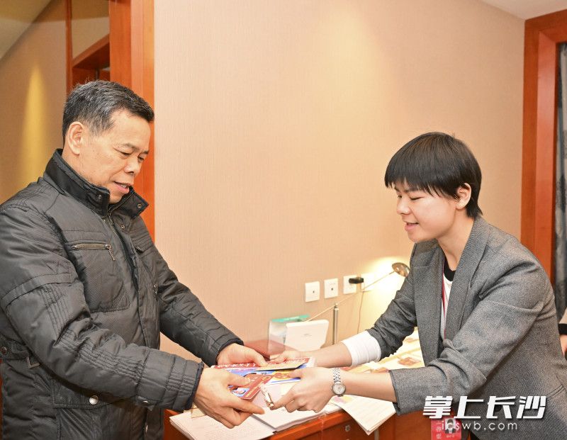 大會(huì)工作人員將證件,、大會(huì)資料等交予前來(lái)報(bào)到的參會(huì)代表,。