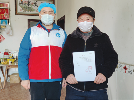 愛爾眼庫及中南大學湘雅醫(yī)學院的工作人員在肖建靈的家中，與肖建靈的丈夫（右）合影留念,。通訊員供圖
