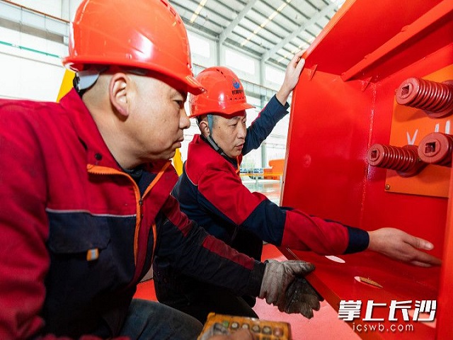 毛強仍在和技術(shù)工人們熱烈探討裝配技巧,。