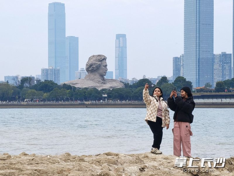尼泊爾留學(xué)生阿妮塔與同伴在江灘公園與青年毛澤東藝術(shù)雕塑合影留念,。