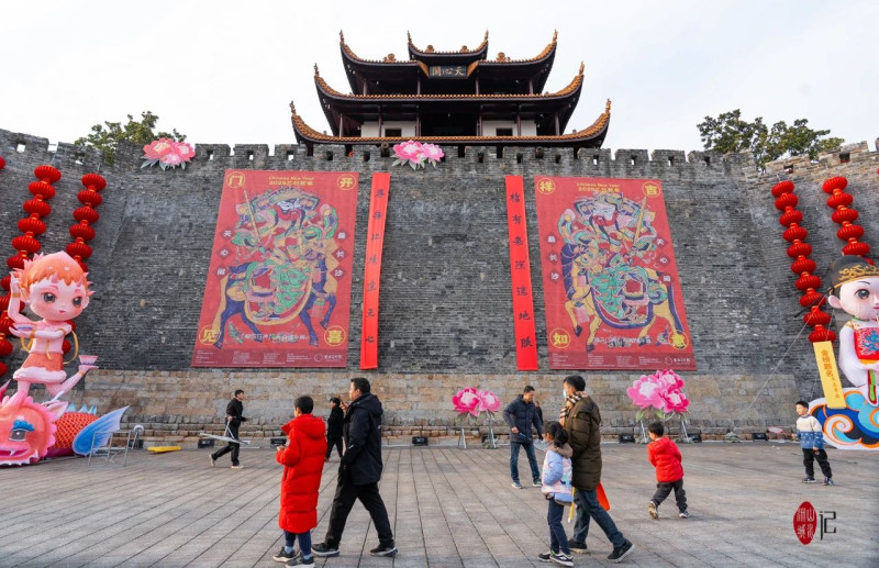游客們?cè)趻炝舜郝?lián)的天心閣城墻下打卡拍照。記者鄒麟 攝