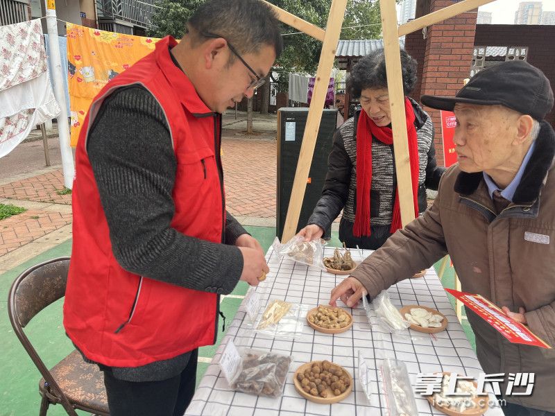 在中藥辨識(shí)展位前,，居民們好奇地辨認(rèn)著各類藥材，不時(shí)向工作人員詢問(wèn)功效。
