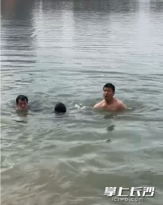 劉輝（右）和另一位沒(méi)有留下姓名的男子一起跳入湖中救人。 視頻截圖