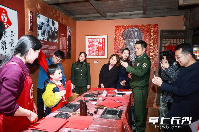 孩子得意地向游客展示自己完成的作品,。