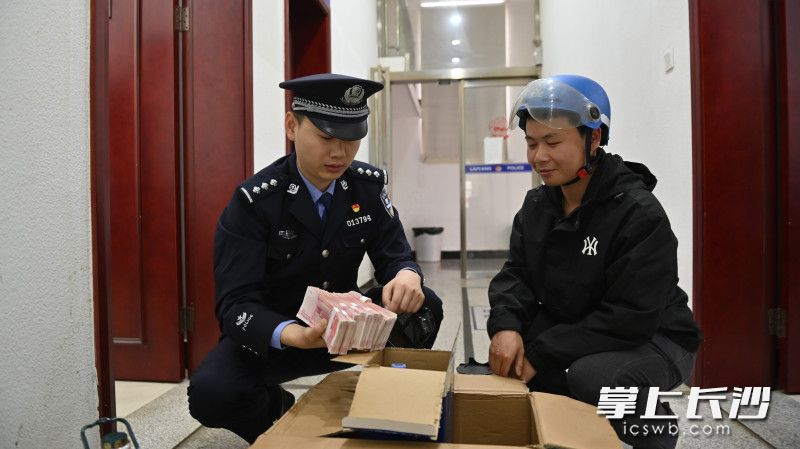 察覺訂單有異，“跑腿小哥”直接將貨物送到派出所,，民警發(fā)現(xiàn)其中藏著7.9萬元現(xiàn)金,。長沙晚報(bào)通訊員 謝鵬 攝