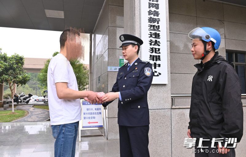 高先生（左）領(lǐng)回了差點(diǎn)被騙的現(xiàn)金，警方也對(duì)其此前的行為進(jìn)行了法治訓(xùn)誡與提醒,。