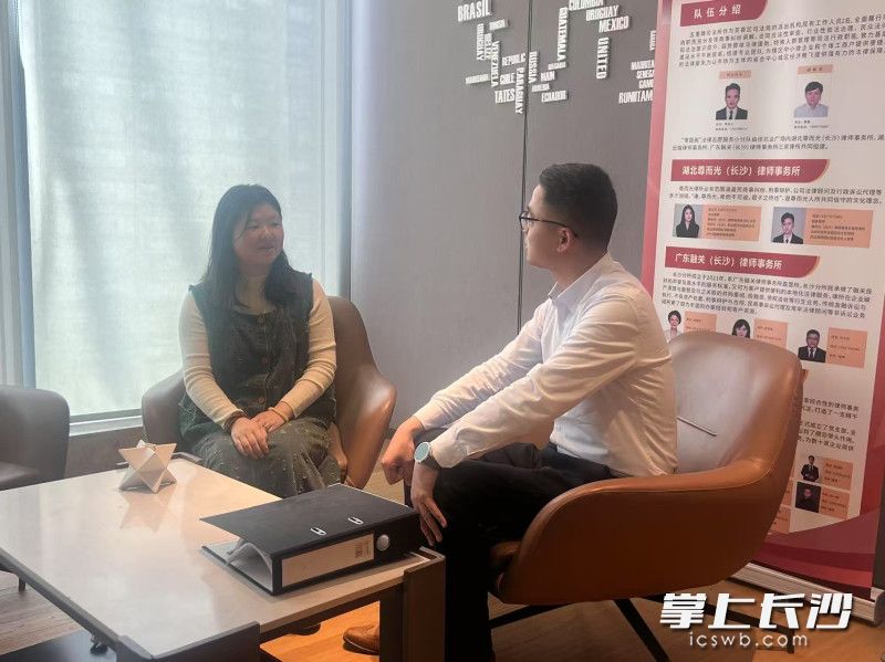 彭行（右）正在忙著給樓宇內(nèi)的職工提供法律咨詢服務(wù)。均為全媒體記者 劉俊 攝