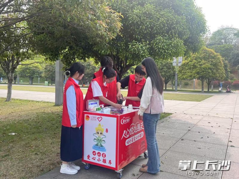 大學(xué)生志愿者推著“心小星”愛(ài)心小推車(chē)為市民提供服務(wù),。均為全媒體記者 劉俊 攝
