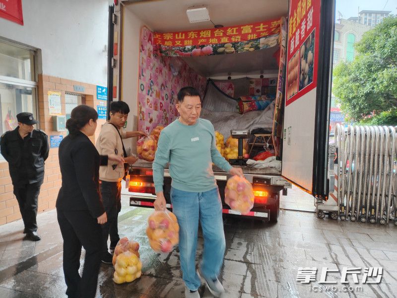 經(jīng)過精心挑選,，周松林（右）購買了280斤煙臺紅富士蘋果,，以感謝物業(yè)工作人員的辛勤付出。