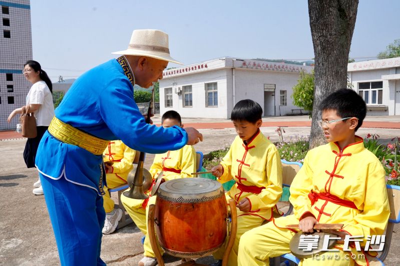 成仁亮指揮孩子們練習(xí)麻山鑼鼓。
