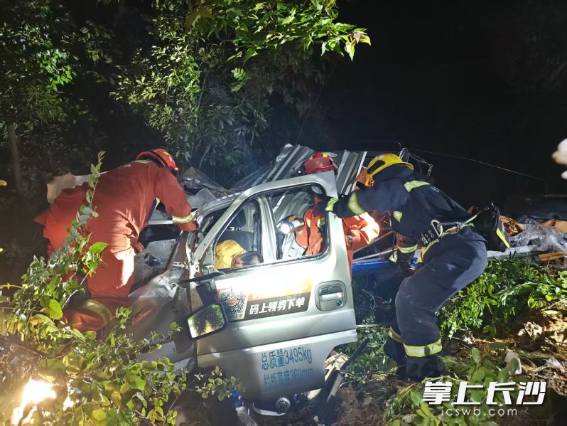 消防員在救助側(cè)翻后被困的貨車司機,。 長沙晚報通訊員 吳坤 供圖