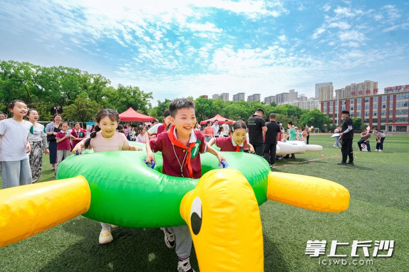 “龜兔賽跑”充氣賽道上，孩子們鉆進(jìn)憨態(tài)可掬的充氣道具,，化身“兔子”或“烏龜”攜手慢行,。