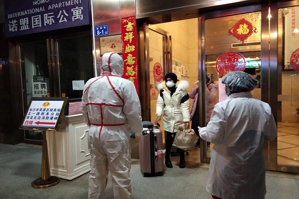 圖為社區(qū)工作人員趕赴酒店轉(zhuǎn)移外籍人員