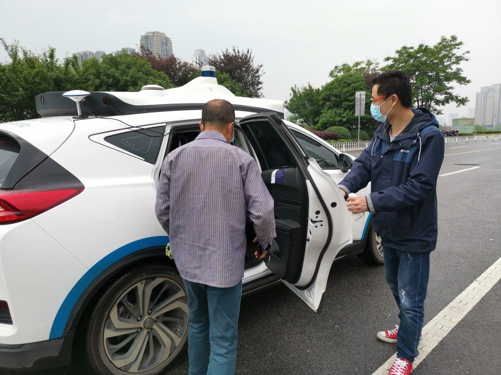 長(zhǎng)沙梅溪湖國(guó)際文化藝術(shù)中心附近，一位市民在隨車(chē)安全員引導(dǎo)下,，準(zhǔn)備登車(chē)試乘百度阿波羅自動(dòng)駕駛出租車(chē),。新華社記者劉良恒 攝