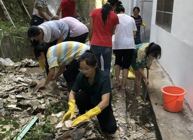 教師何小玲與志愿者一起清理校園建筑垃圾
