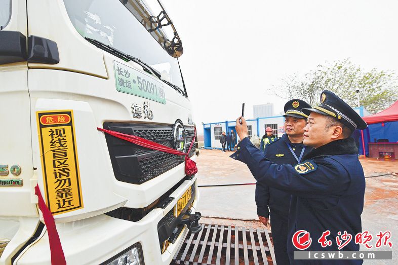 只要用手機(jī)“掃一掃”專用標(biāo)識牌上的編碼，渣土車的各類信息一目了然,。王志偉 攝