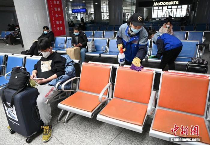 1月25日，呼和浩特火車站,，工作人員在候車室內(nèi)對座椅消毒,。中新社記者 劉文華 攝