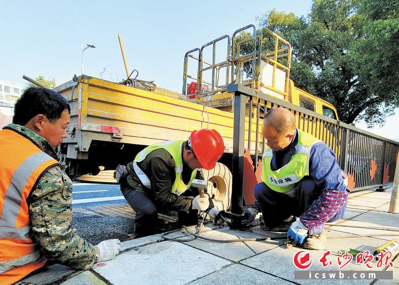 市政工人正在修補人行道上的破損路面,，保障通行安全。吳峰榮 攝