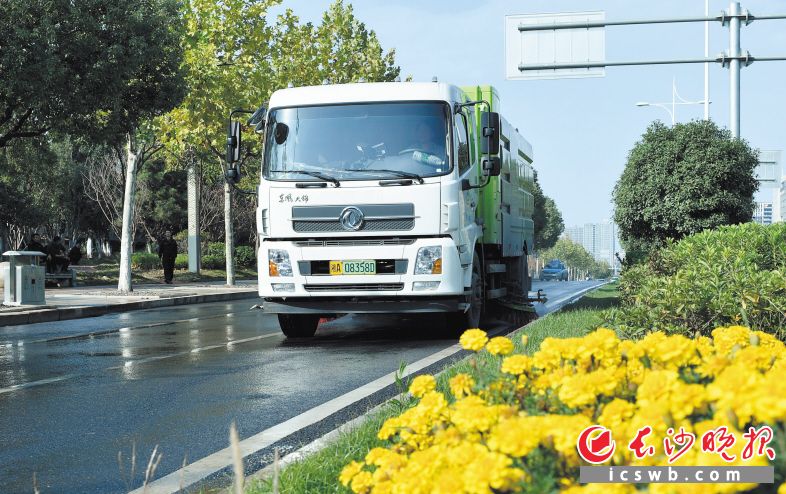 環(huán)衛(wèi)作業(yè)車輛駛過，路面一片潔凈清爽,。鄒麟 攝