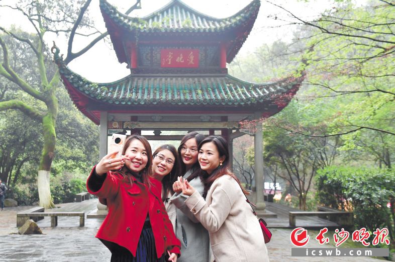 　3月20日下午，岳麓山愛(ài)晚亭前,，來(lái)自廣東江門(mén)的年輕游客在拍照“打卡”,。長(zhǎng)沙晚報(bào)全媒體記者 王志偉 攝