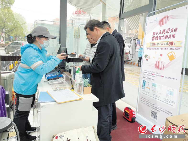 在工作人員的介紹下，消費者使用數(shù)字人民幣支付,，享受加油站滿減福利,。　　長沙晚報全媒體記者 朱澤寰 攝