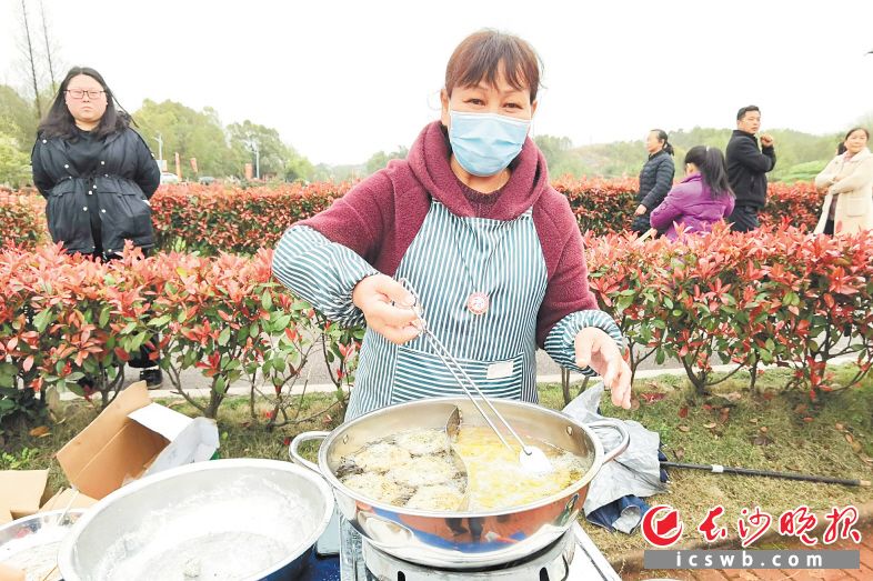 看著花田音樂節(jié)引來游人如織,，村民歐瑞南連忙亮出自己的好手藝——油炸蒿子粑粑。張禹 攝