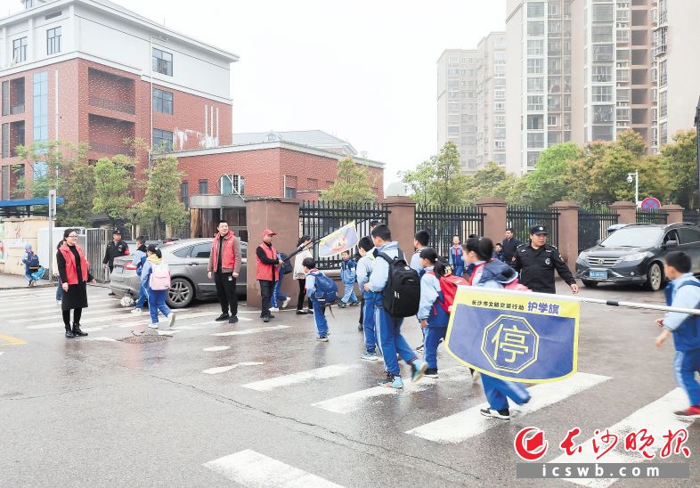 4月7日,，長沙高新區(qū)雷鋒街道黨員干部化身紅馬甲志愿者,，護(hù)送學(xué)生過馬路。受訪者供圖