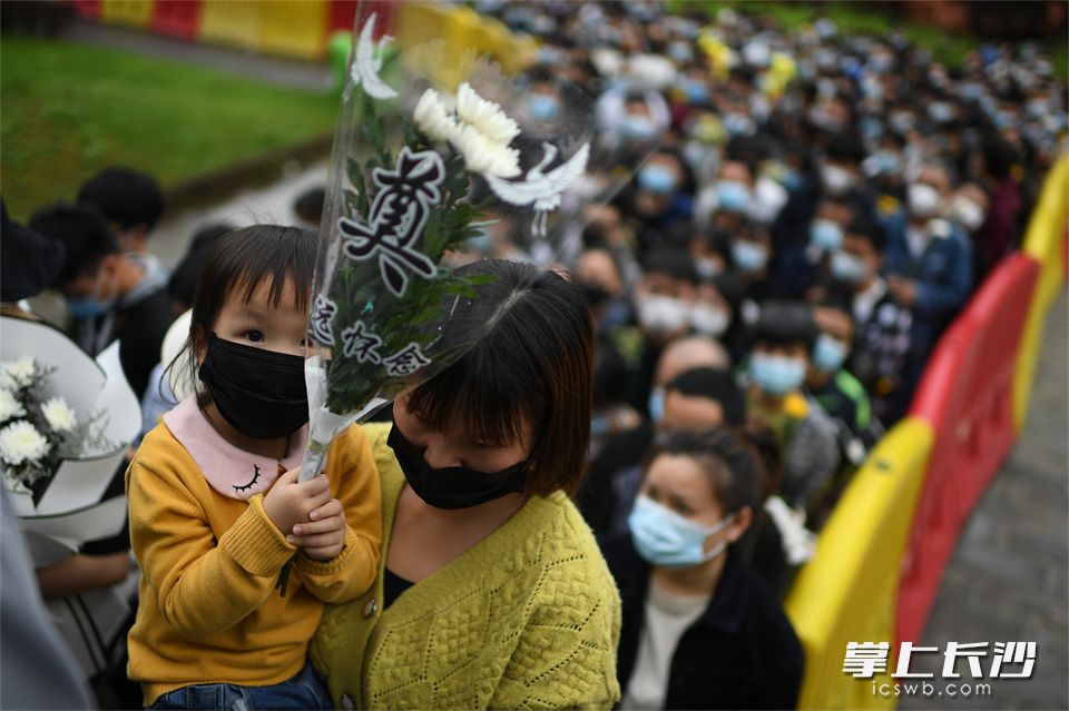 5月23日,，一位女孩被父母抱著進入殯儀館緬懷袁老,。