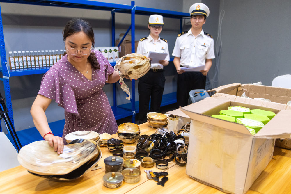6月19日,，第三屆中非經(jīng)貿(mào)博覽會首批入境參展展品完成通關(guān)手續(xù)后運抵長沙國際會展中心,，圖為博覽會組委會工作人員（左一）取出包裹內(nèi)的展品。新華社記者陳思汗 攝
