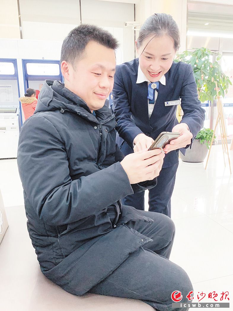 　　湖南銀行長(zhǎng)沙分行經(jīng)辦人員指導(dǎo)客戶申請(qǐng)“星城閃貸”。受訪方供圖