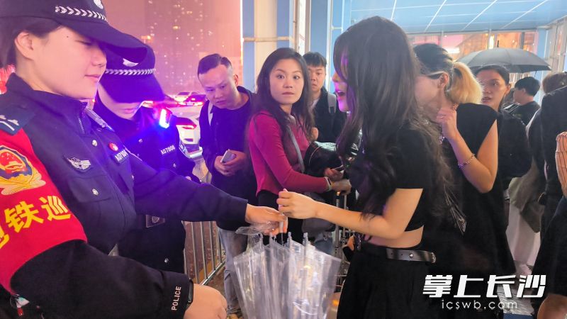 民輔警給游客發(fā)傘。