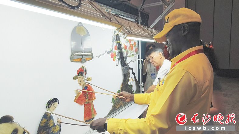 來(lái)自烏干達(dá)的文森特·布瓦納·唐有板有眼地操作起人偶，跟皮影傳承人演了一段“對(duì)手戲”,。長(zhǎng)沙晚報(bào)全媒體記者 寧莎鷗 攝