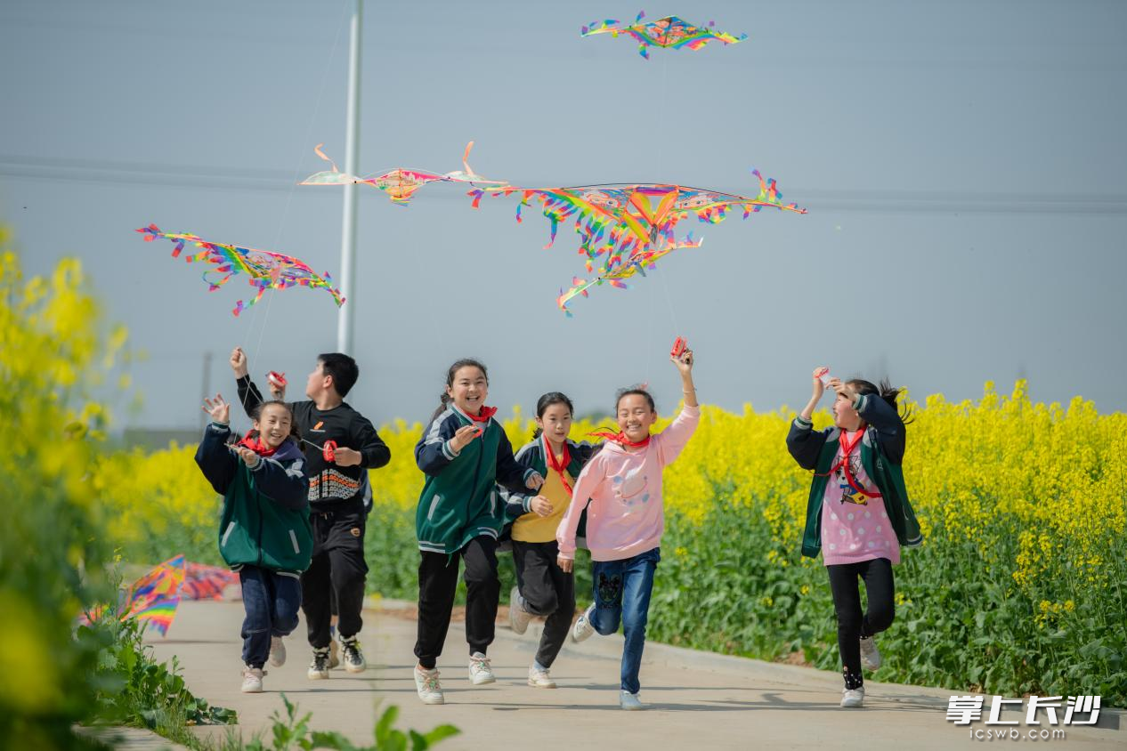 孩子們奔跑在花叢中，愉快地放飛著風箏,。