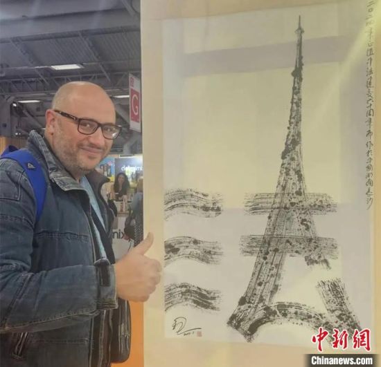The "One Character Makes You Fall in Love with China" Chinese Cultural Exhibition was held in France in May 2024. The photo shows a French visitor giving a thumbs-up to artist Song Dan's Chinese character artwork titled "Tower of Sino-French Friendship".