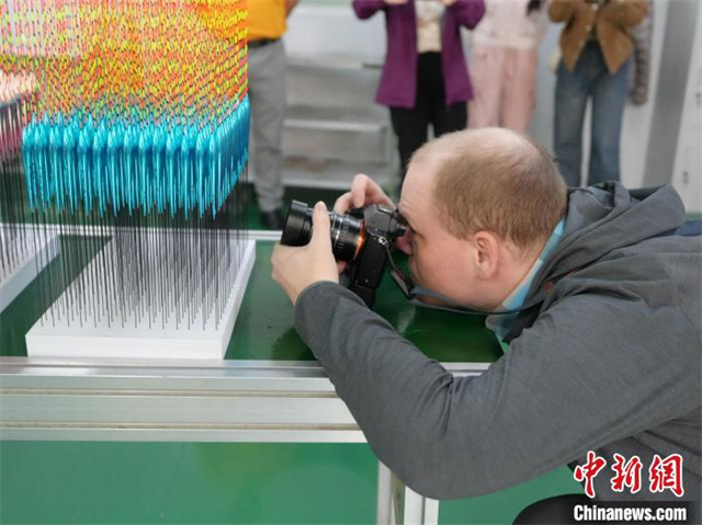 The photo shows Frantisek Bina, a photographer from the Czech Republic, taking photos of fishing floats. (Photo/Yang Huafeng, Chinanews)