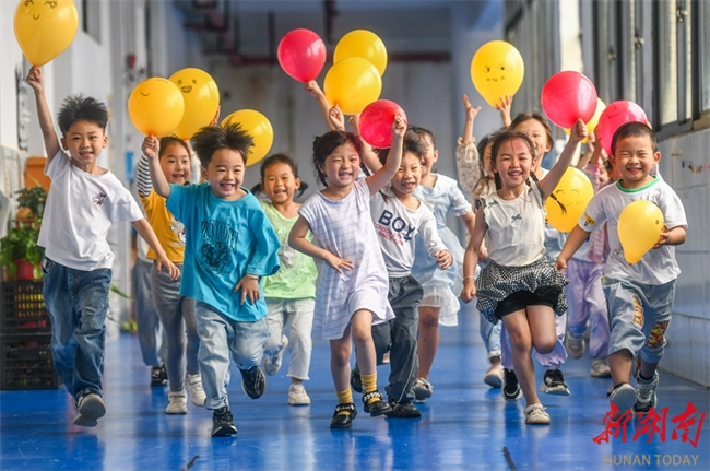 The photo, taken on May 7, shows kids running with smiling balloons at a kindergarten in Daoxian County, Hunan. (Photo/Jiang Keqing and Jiang Zhengzheng)