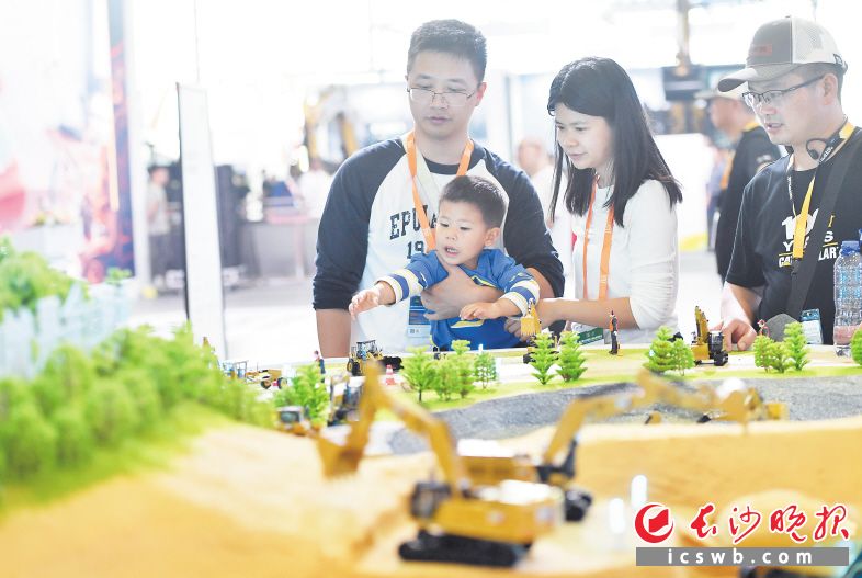 一名兒童沖著展出的挖掘機模型伸出雙手,。長沙晚報全媒體記者 王志偉 劉曉敏 攝影報道